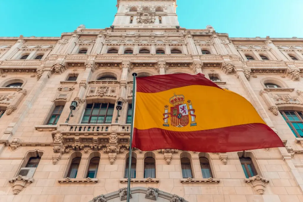 The flag of Spain flies in front of a building; Spanish citizenship by ancestry is a valid pathway to gaining nationality.