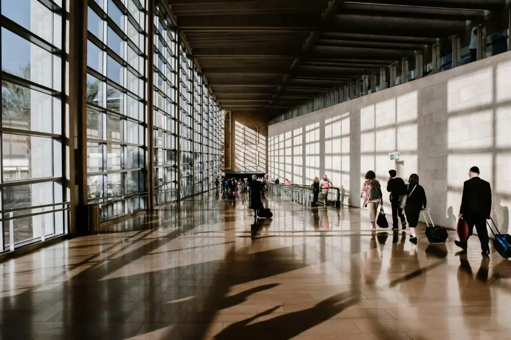 Travelers walk through an airport; Italian citizenship applications reform is bringing changes to passports and ID cards for travelers, as well.